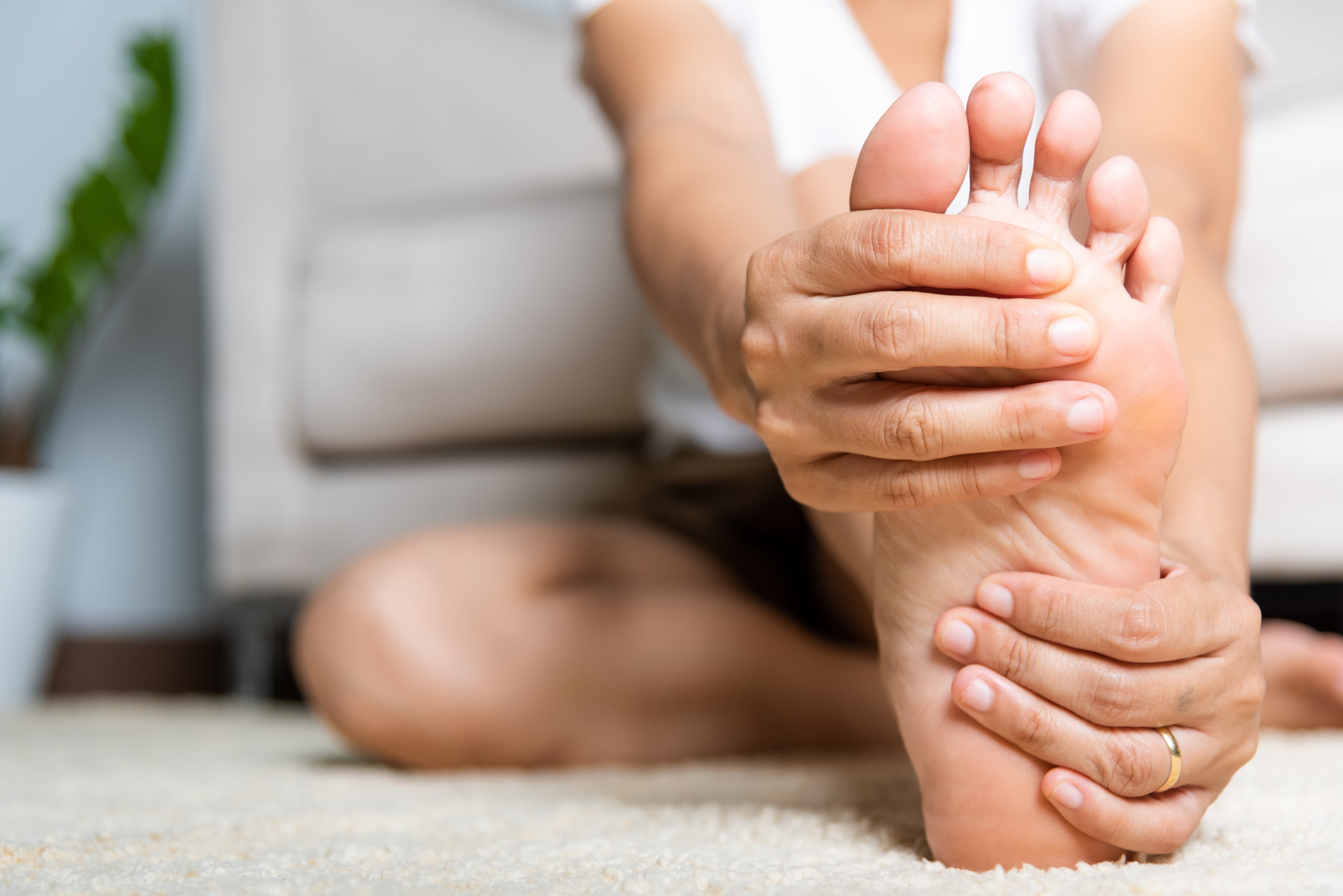 A Close up shot of the underside of a woman's foot as she performs a seated hamstring stretch